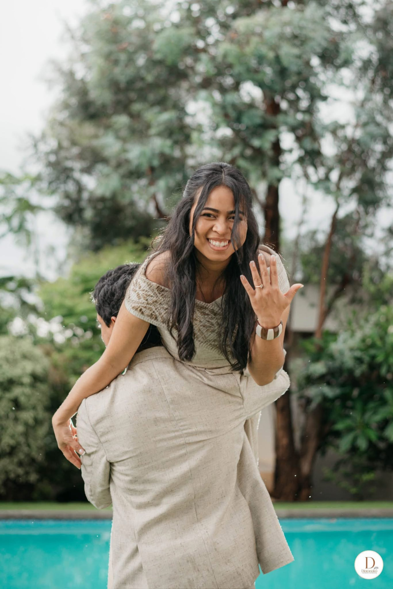 Christelle portée par Joan, montrant sa bague de fiançailles en riant